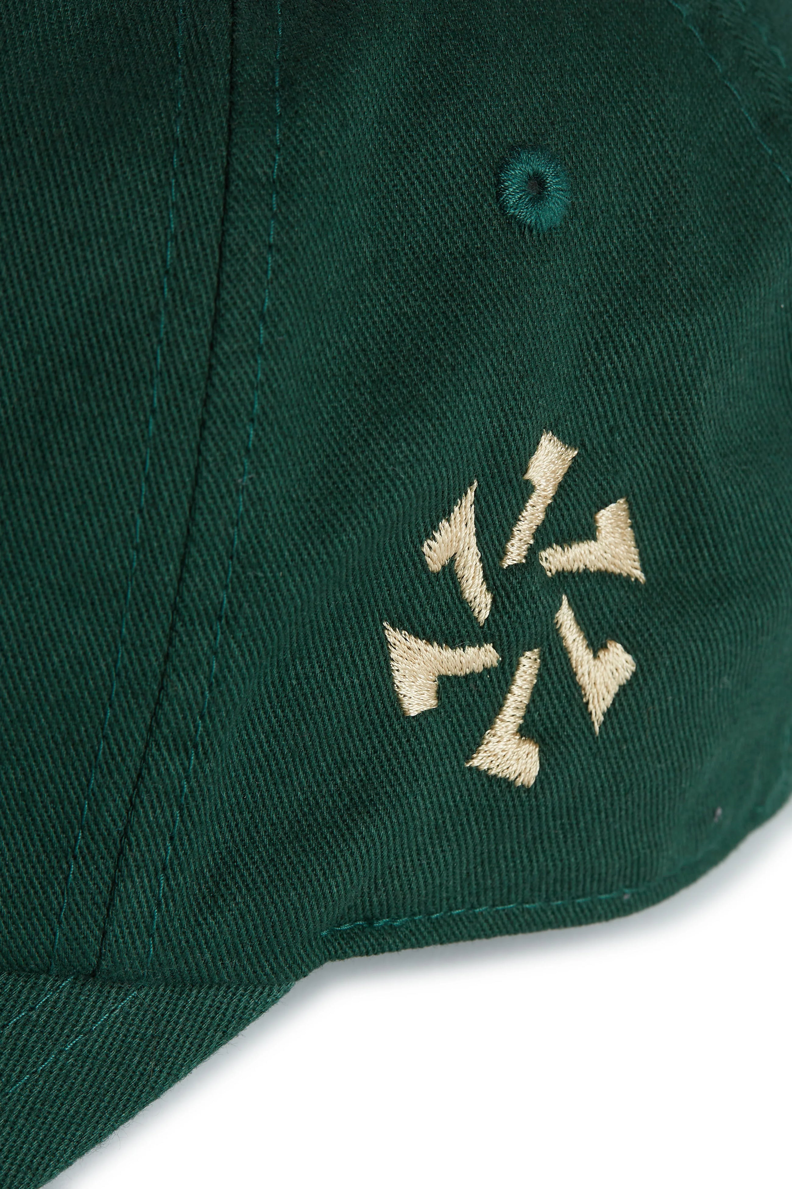 Rex Club | Close-up of the Rex Club Goat - Dark Green cap, featuring a beige embroidered design with six abstract shapes in a circular pattern on the side. | Custom Caps | Custom Hats | Team Headwear | UK