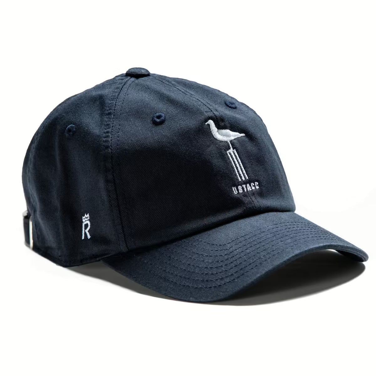 Rex Club | The St Andrews University CC - Slouch by Rex Club is a navy 100% cotton cap with an embroidered white seagull on a post, "US TAGC" below, and a small crown with "R" on the side. | Custom Caps | Custom Hats | Team Headwear | UK