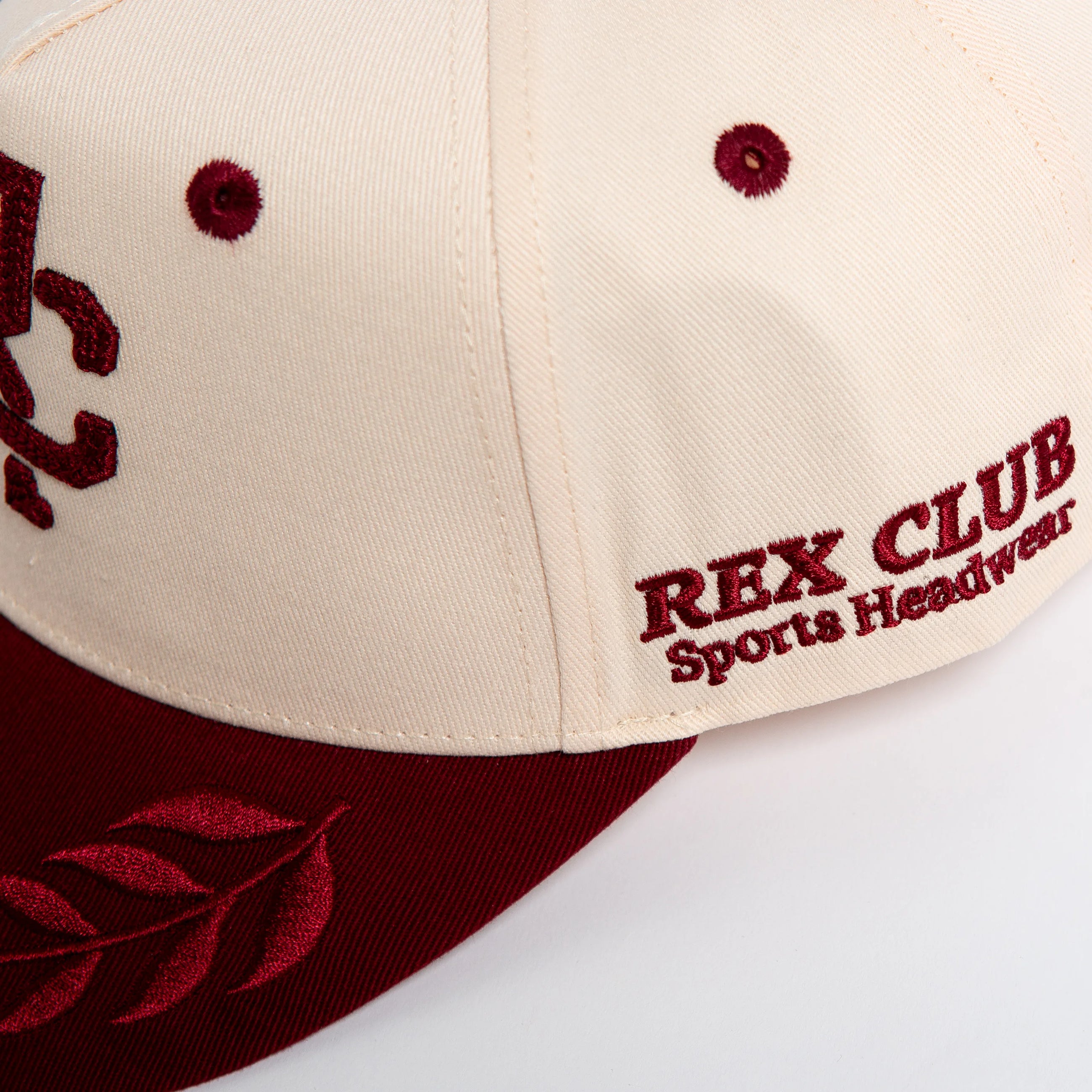 Rex Club | The RC - Victor - Two Tone by Rex Club is a cream and maroon cotton baseball cap with red "REX CLUB Sports Headwear" embroidery on the front, a red laurel on the brim, and an adjustable fit for most sizes. | Custom Caps | Custom Hats | Team Headwear | UK