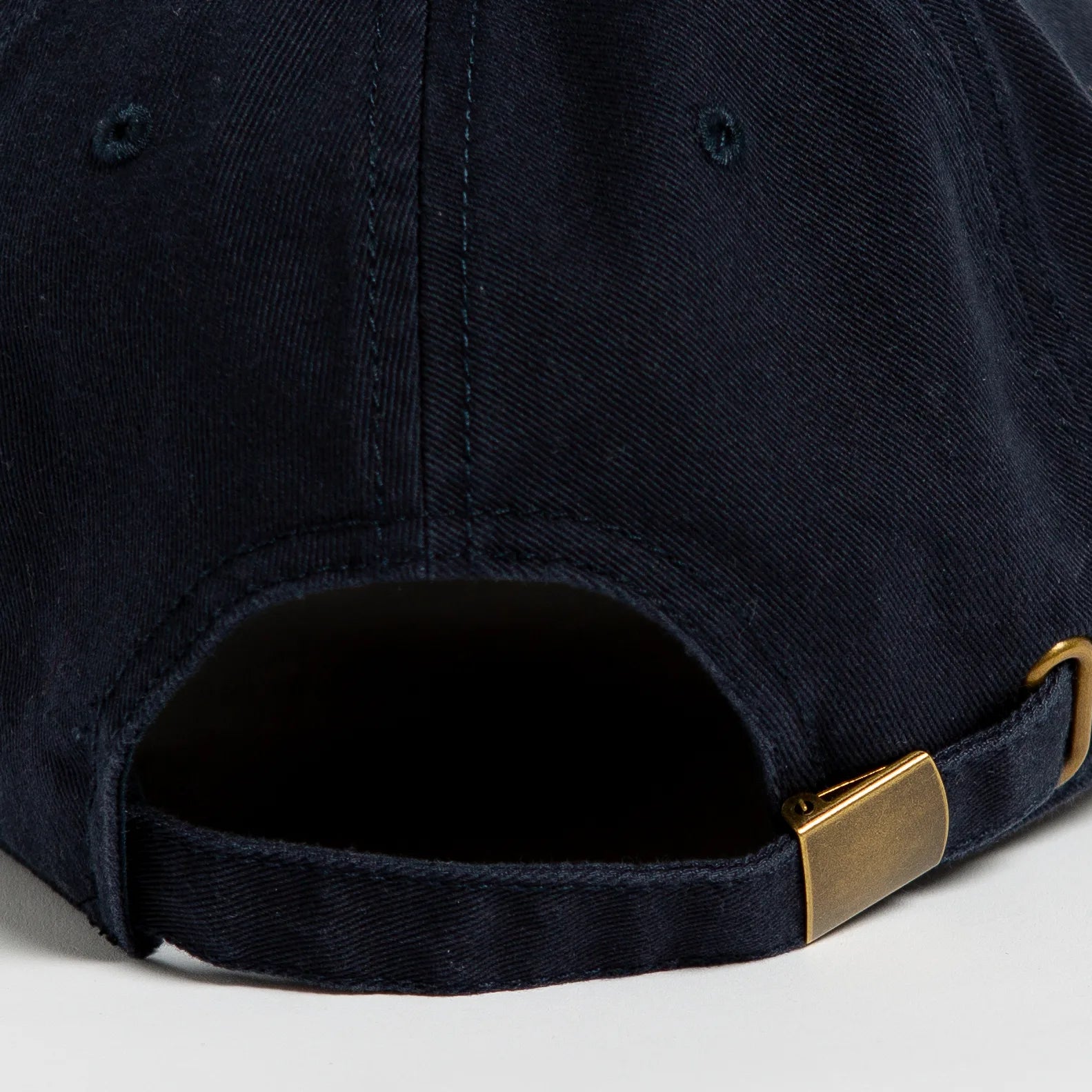 Rex Club | Close-up of the back of the Rex Club Headwear Co. navy baseball cap by Rex Club, crafted from 100% cotton with a curved opening and an adjustable strap featuring a brass-colored metal buckle. | Custom Caps | Custom Hats | Team Headwear | UK