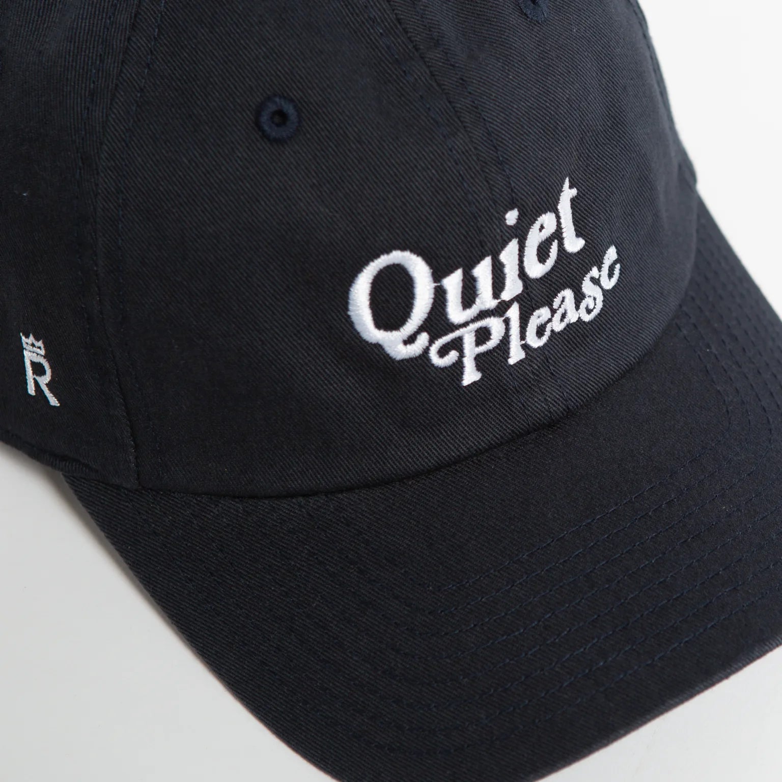 Rex Club | A navy slouch baseball cap by Rex Club, featuring "Quiet Please" embroidered in white on the front in a classic style, with a small letter "R" and crown symbol on the side. | Custom Caps | Custom Hats | Team Headwear | UK