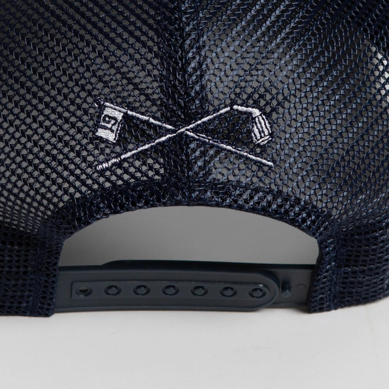 Rex Club | Close-up of the Rex Club Golf: Quiet Please - Navy Trucker hat, a mesh snapback styled like a classic trucker cap, featuring embroidered crossed golf clubs and a "19" flag above the adjustable strap. | Custom Caps | Custom Hats | Team Headwear | UK
