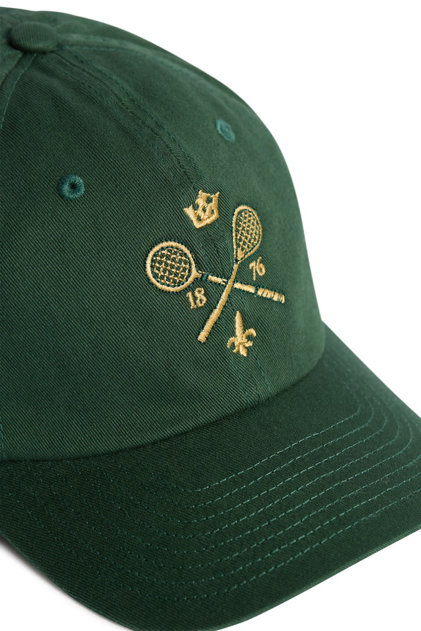 Rex Club | A green MTRC - Green cap by Rex Club, featuring gold embroidery of two crossed tennis rackets with a crown above, the numbers 18 and 76 on either side, and a small fleur-de-lis below. | Custom Caps | Custom Hats | Team Headwear | UK