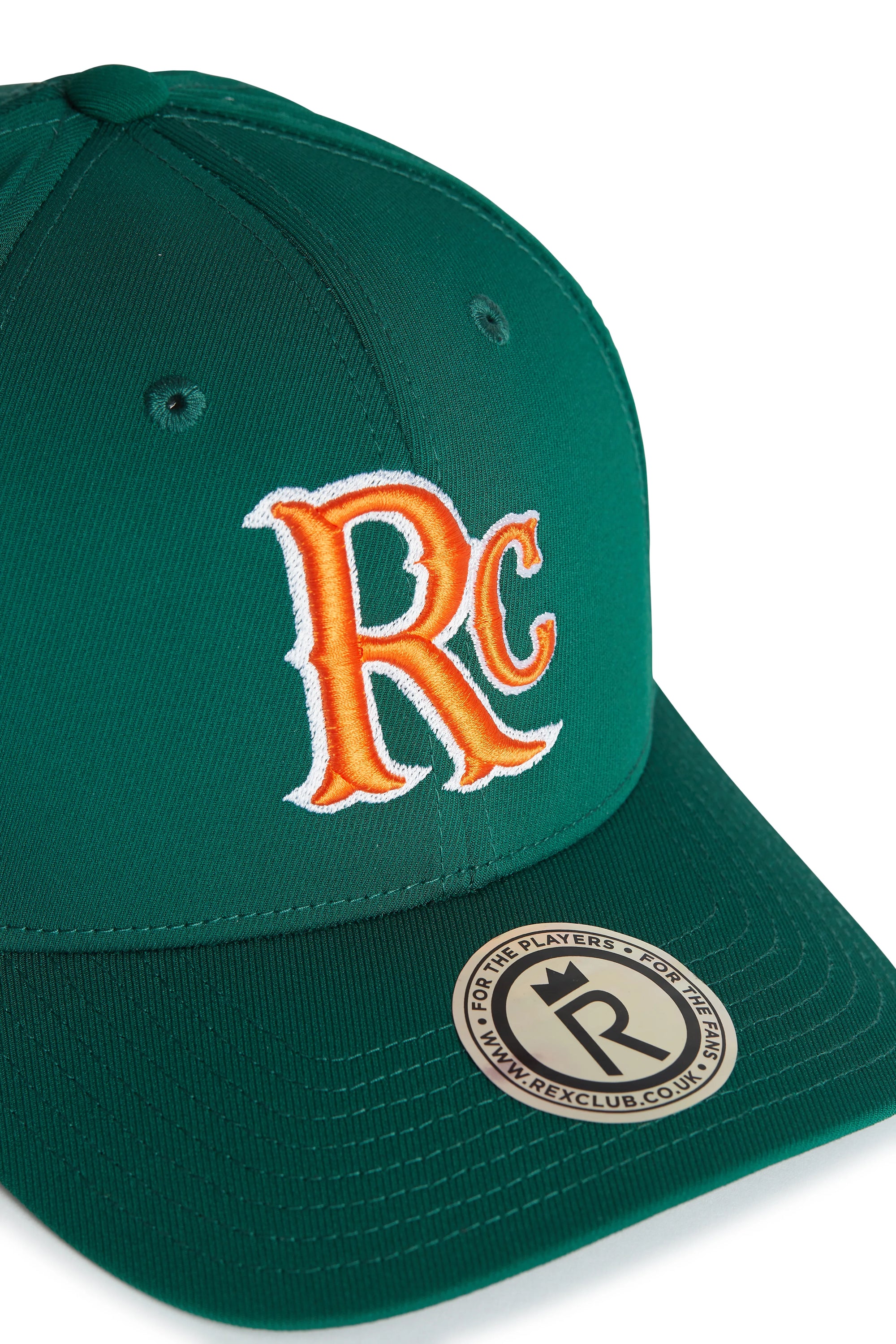 Rex Club | The RC 26 Performance cap by Rex Club is green with "RC" monogrammed in orange and white embroidery on the front. A round sticker on the bill reads "For the players - REXCLUB.CO.UK". Ideal for sports teams or daily wear. | Custom Caps | Custom Hats | Team Headwear | UK