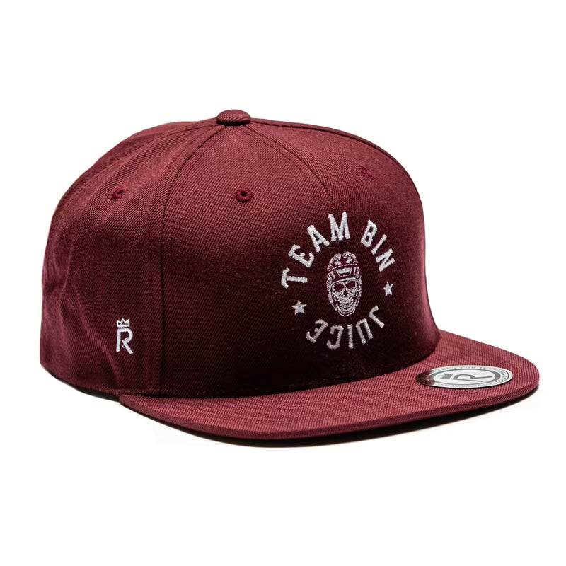 Rex Club | The Rex Club Team Bin Juice Benchwarming Snapback in maroon features white "TEAM BIN JUICE" text and a masked face on the front, a crowned "R" on the side, and a round sticker on its flat brim. | Custom Caps | Custom Hats | Team Headwear | UK