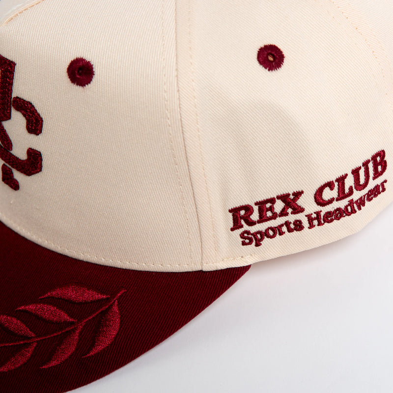 Rex Club | The RC - Victor - Two Tone by Rex Club is a cream and maroon cotton baseball cap with red "REX CLUB Sports Headwear" embroidery on the front, a red laurel on the brim, and an adjustable fit for most sizes. | Custom Caps | Custom Hats | Team Headwear | UK