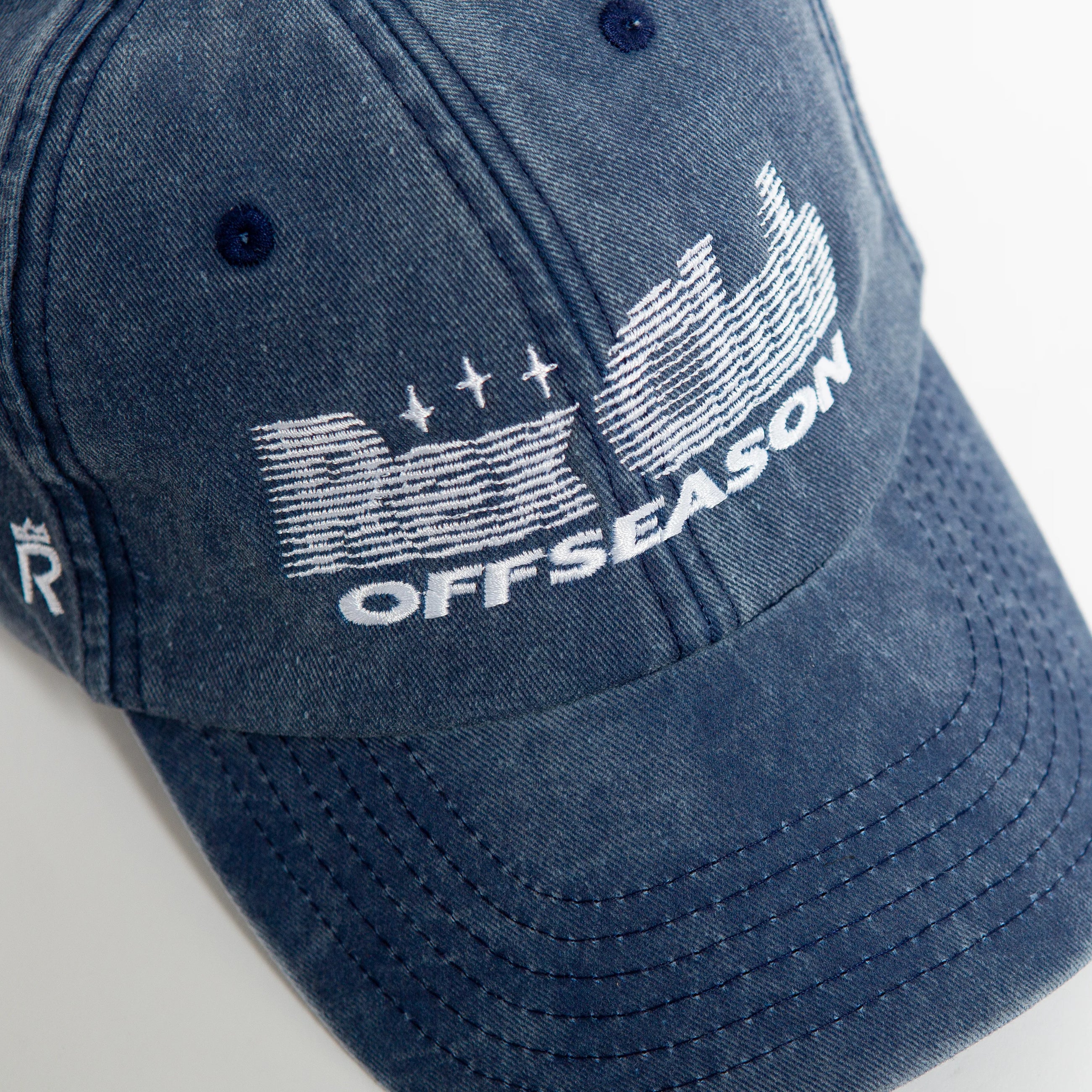 Rex Club | The Rex Club Offseason 2025 cap is a blue denim baseball hat in Washed Navy, made from 100% cotton. It features white "OFFSEASON" embroidery with stylized letters, three stars and lines, plus blue eyelets and classic visible stitching. | Custom Caps | Custom Hats | Team Headwear | UK