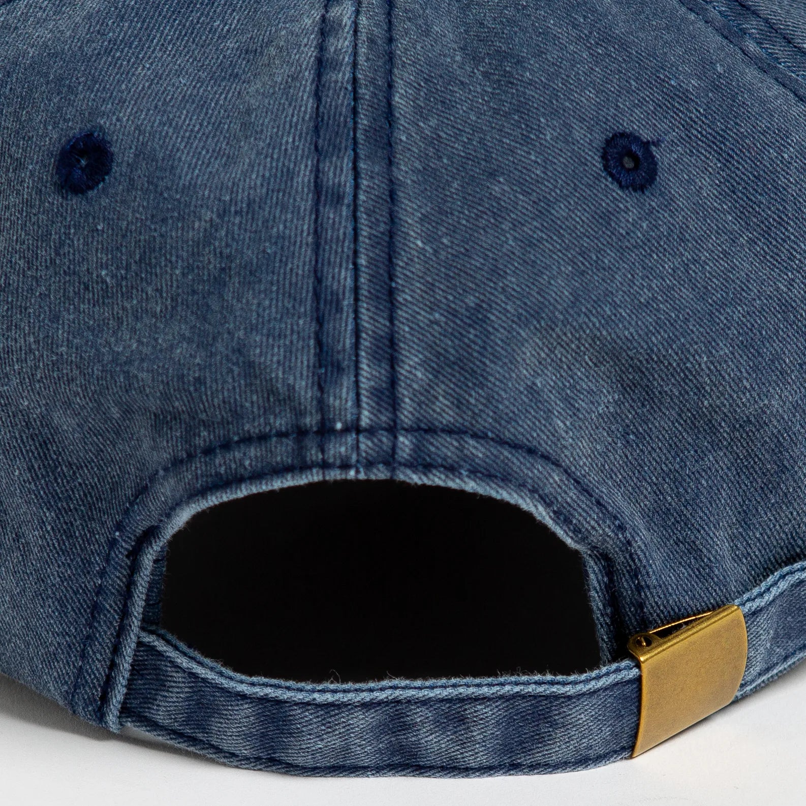 Rex Club | Close-up of the back of Rex Club's Offseason 2025 cap in washed navy denim, made from 100% cotton with visible stitching, two eyelets, and a brass-buckle adjustable strap. The back opening is centered at the bottom. | Custom Caps | Custom Hats | Team Headwear | UK