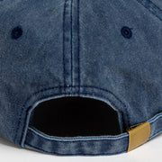 Rex Club | Close-up of the back of Rex Club's Offseason 2025 cap in washed navy denim, made from 100% cotton with visible stitching, two eyelets, and a brass-buckle adjustable strap. The back opening is centered at the bottom. | Custom Caps | Custom Hats | Team Headwear | UK