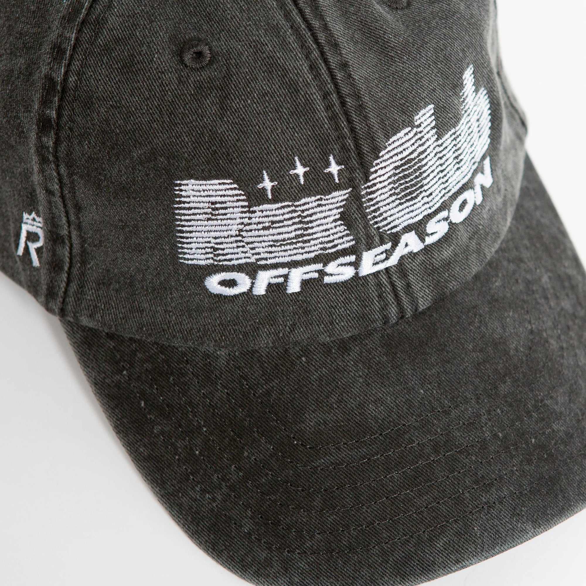 Rex Club | A close-up of the Rex Club Offseason 2025 washed black denim cap in 100% cotton, featuring white "OFFSEASON" embroidery and stylized "R" and "C" graphics with lines and stars. | Custom Caps | Custom Hats | Team Headwear | UK