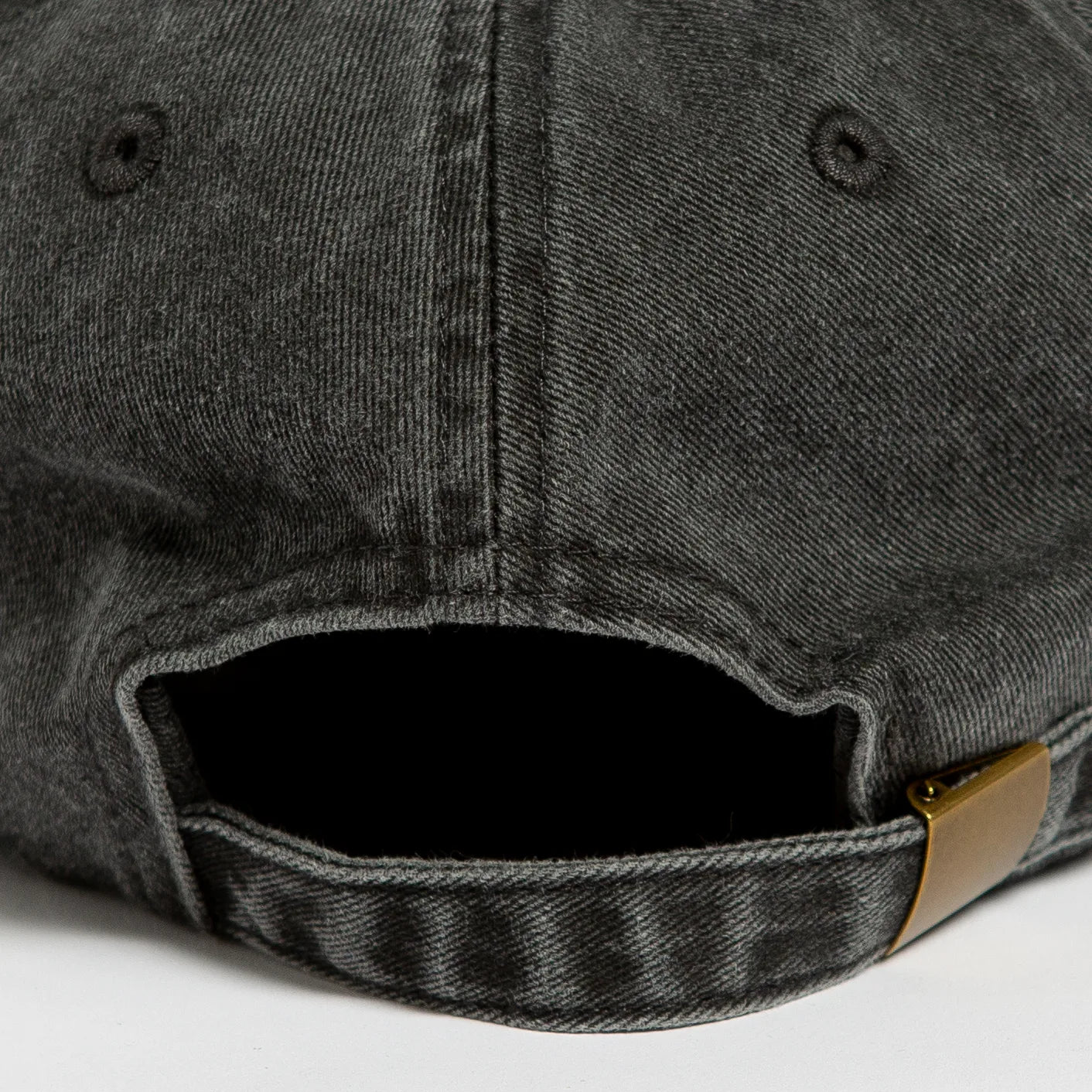 Rex Club | Close-up of the back of the Rex Club Offseason 2025 cap in Washed Black, crafted from 100% cotton with visible stitching, a fabric strap, brass-colored adjustable buckle, and a small embroidered eyelet. | Custom Caps | Custom Hats | Team Headwear | UK
