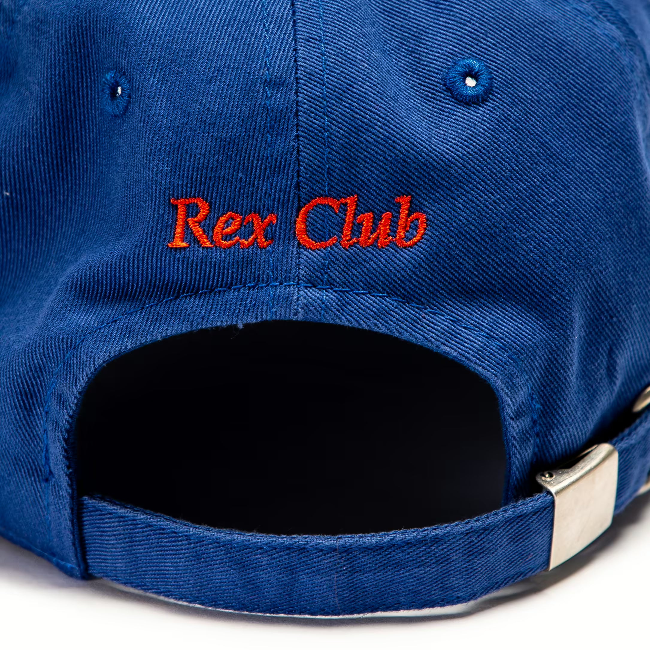 Rex Club | Close-up of the back of the OFFSEASON 23 Slouch by Rex Club, a blue 100% cotton baseball cap featuring "Rex Club" embroidered in red above the adjustable strap. | Custom Caps | Custom Hats | Team Headwear | UK