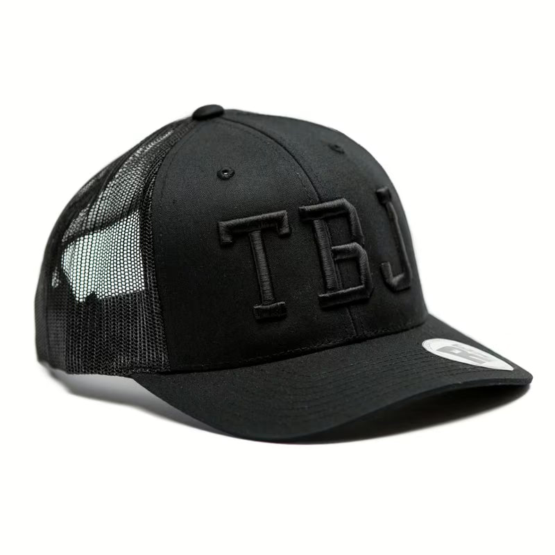 Rex Club | The Rex Club Team Bin Juice - Blackout is a black trucker hat with mesh sides and back, featuring bold "TBJ" embroidery on the front and a small sticker on the brim. | Custom Caps | Custom Hats | Team Headwear | UK