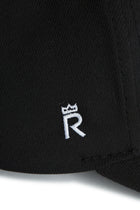 Rex Club | Close-up of RC 26 Performance black jersey by Rex Club, highlighting a white embroidered “R” monogram crowned with a small symbol—signature detail on sports apparel. | Custom Caps | Custom Hats | Team Headwear | UK