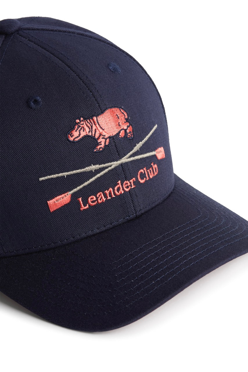 Rex Club | This premium bespoke navy blue baseball cap by Rex Club features an embroidered pink hippopotamus above two crossed oars and the words “Leander Club” in pink stitching on the front—a stylish nod to one of the world’s most renowned rowing clubs. | Custom Caps | Custom Hats | Team Headwear | UK