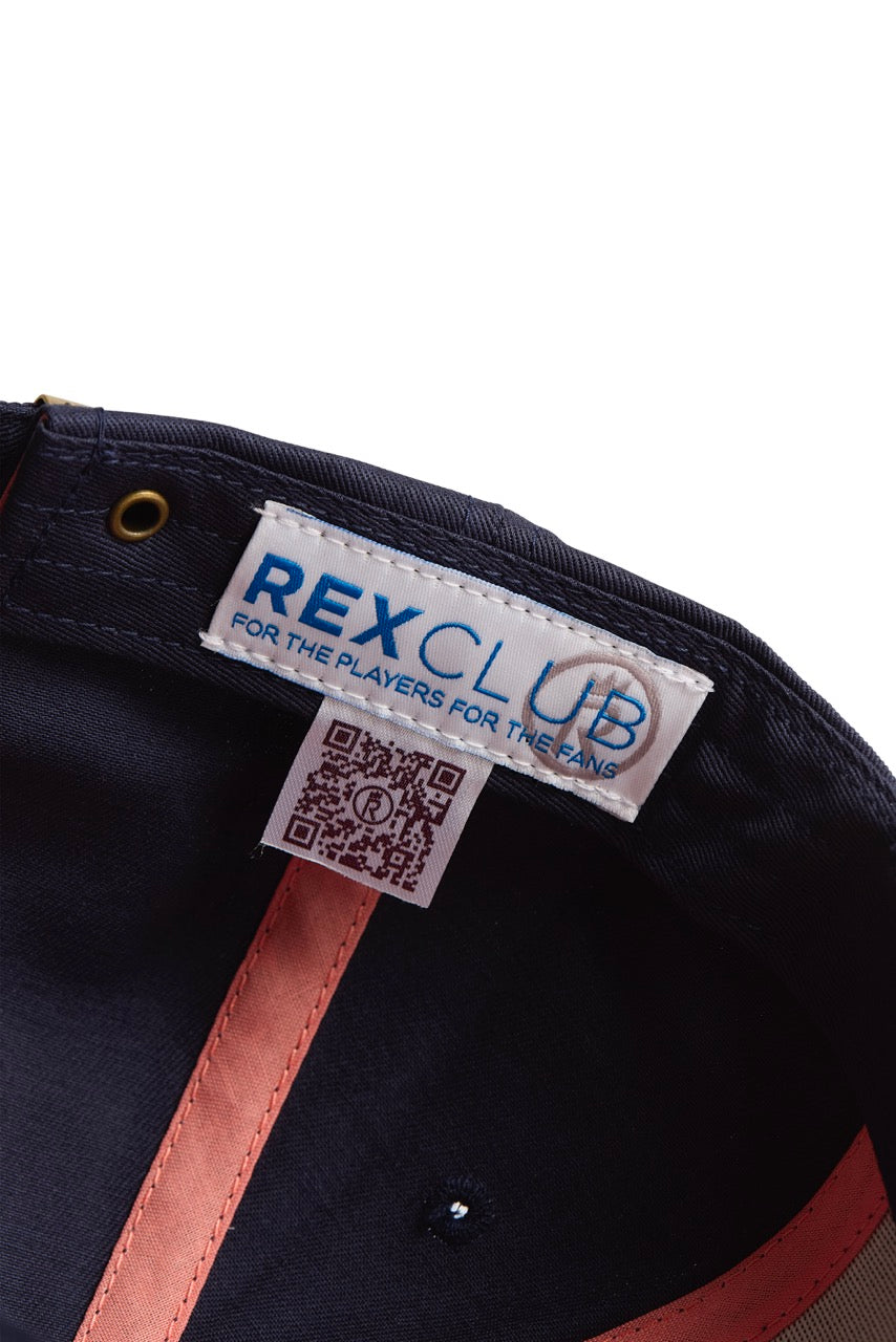 Rex Club | Close-up of a premium bespoke Leander Club cap’s inside label from Rex Club, which reads “REXCLUB FOR THE PLAYERS FOR THE FANS,” featuring a QR code beneath and distinctive red stitching on the fabric—a detail inspired by elite traditions like those of the Leander Club rowing club. | Custom Caps | Custom Hats | Team Headwear | UK