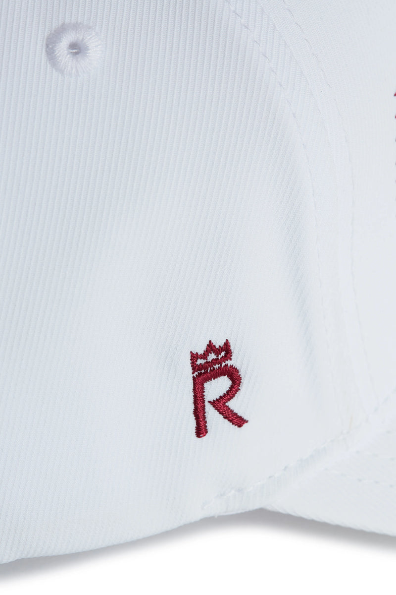 Rex Club | Close-up of a white performance cap from Rex Club, featuring a small maroon "R" with a crown symbol embroidered above it—perfect for fans of the OFFSEASON 26 - Navy collection seeking stylish headwear. | Custom Caps | Custom Hats | Team Headwear | UK