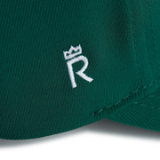 Rex Club | Close-up of the green RC 26 Performance jersey fabric by Rex Club, featuring a white embroidered "R" topped with a crown—a stylish, sporty monogram detail. | Custom Caps | Custom Hats | Team Headwear | UK