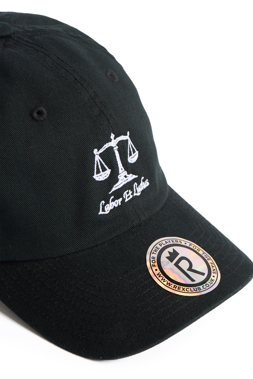 Rex Club | Black baseball cap featuring an embroidered white scales of justice graphic and the words “Labor Et Ludus” on the front, this versatile work and play cap from Rex Club is crafted from 100% cotton for comfort and durability. Finished with a branded Rex Club sticker on the brim, it comes in one size that fits most. | Custom Caps | Custom Hats | Team Headwear | UK