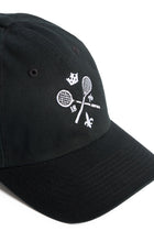 Rex Club | The Rex Club MTRC - Black cap showcases white embroidered details, including two crossed tennis rackets, the numbers 18 and 76, a crown above, and a fleur-de-lis below—seen from an angle on a white background—making it ideal official club merchandise for any enthusiast. | Custom Caps | Custom Hats | Team Headwear | UK