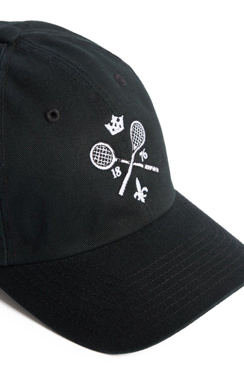 Rex Club | The Rex Club MTRC - Black cap showcases white embroidered details, including two crossed tennis rackets, the numbers 18 and 76, a crown above, and a fleur-de-lis below—seen from an angle on a white background—making it ideal official club merchandise for any enthusiast. | Custom Caps | Custom Hats | Team Headwear | UK