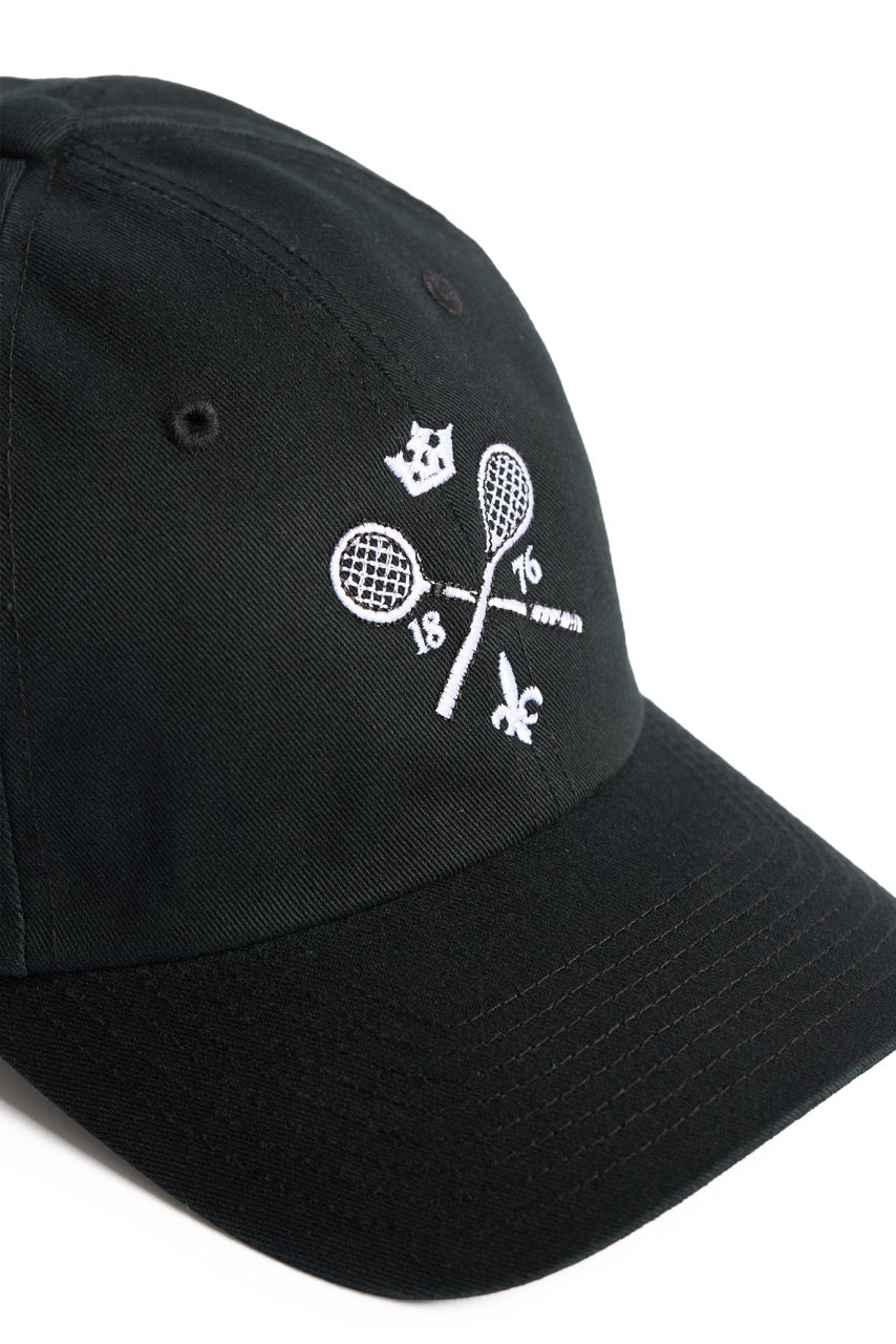 Rex Club | The Rex Club MTRC - Black cap showcases white embroidered details, including two crossed tennis rackets, the numbers 18 and 76, a crown above, and a fleur-de-lis below—seen from an angle on a white background—making it ideal official club merchandise for any enthusiast. | Custom Caps | Custom Hats | Team Headwear | UK