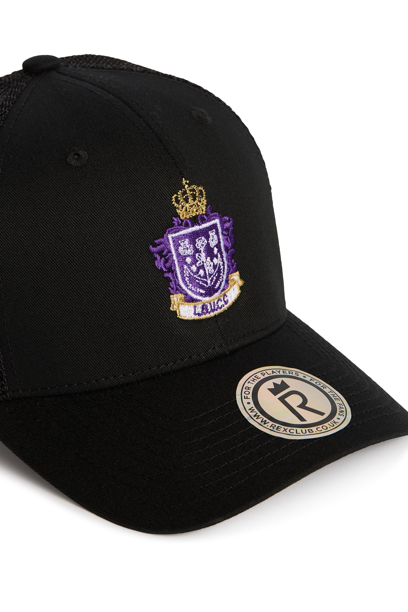 Rex Club | Here is a rewritten version of the sentence using your product data: The Leeds Beckett University Cricket Club Trucker by Rex Club is a black baseball cap made from a durable polyester-cotton blend, adorned with a purple and gold embroidered crest featuring a crown. A round sticker on the brim displays text encircling a bold “R”. | Custom Caps | Custom Hats | Team Headwear | UK