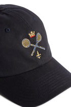 Rex Club | A close-up of a navy Rex Club MTRC cap featuring embroidered gold lacrosse sticks crossed, a gold crown above, and a small gold fleur-de-lis below the sticks—perfect for fans of Manchester Tennis & Racquets Club caps and discerning club merchandise collectors. | Custom Caps | Custom Hats | Team Headwear | UK
