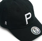 Rex Club | The Cornish Pirates - P Slouch by Rex Club is a black cap with a bold white "P" on the front, a small crowned "R" on the side, and a silver "REXCLUB.COM" sticker—bringing Champ Rugby spirit and Cornish Pirates flair to your style. | Custom Caps | Custom Hats | Team Headwear | UK