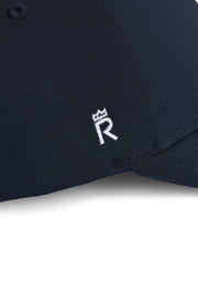 Rex Club | Close-up of the Rex Club Clydach CC Stretch cap in navy blue, showcasing a small white embroidered “R” with a crown above it on the front panel. Crafted from a premium polyester-cotton-spandex blend, this fitted cap delivers a comfortable stretch fit for all-day wear. | Custom Caps | Custom Hats | Team Headwear | UK