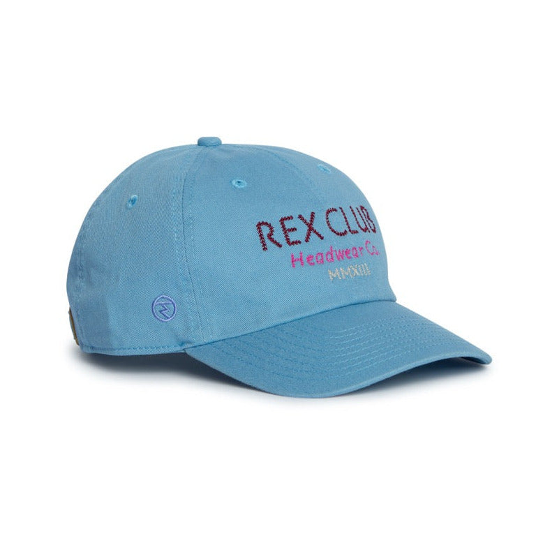 Rex Club | Introducing the In the details - Cornflower cap by Rex Club—a light blue cotton slouch cap featuring “REX CLUB Headwear Co. MMXIII” embroidered on the front in purple and red. Perfect for summer, this hat offers a curved brim and stitched eyelets for added breathability. | Custom Caps | Custom Hats | Team Headwear | UK