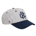 Rex Club | Introducing the RC - Baseball Pin - SS26 Navy cap by Rex Club: This white cotton baseball cap features thin navy blue vertical stripes, a solid navy blue brim, and a large embroidered logo on the front in navy. Designed for comfort with an adjustable strap, this one-size-fits-most cap combines style and versatility. | Custom Caps | Custom Hats | Team Headwear | UK