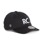 Rex Club | A navy slouch cap from Rex Club, crafted from 100% cotton, features bold white “RC” letters on the front, a round logo patch on the brim, and smaller embroidered symbols on the side for added detail. The model is named RC 3d 26. | Custom Caps | Custom Hats | Team Headwear | UK