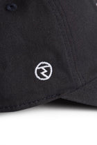 Rex Club | Close-up of the Rex Club RC 3d 26 - Navy cap, crafted from 100% cotton in a deep navy shade, featuring a small white circular logo with a stylized letter “M” embroidered on the fabric. | Custom Caps | Custom Hats | Team Headwear | UK