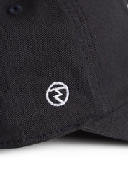 Rex Club | Close-up of the Rex Club RC 3d 26 - Navy cap, crafted from 100% cotton in a deep navy shade, featuring a small white circular logo with a stylized letter “M” embroidered on the fabric. | Custom Caps | Custom Hats | Team Headwear | UK