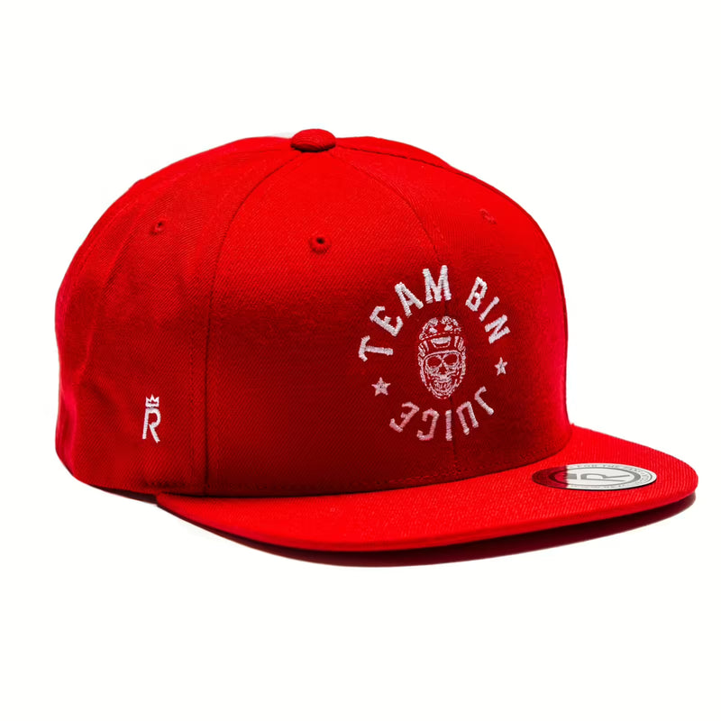Rex Club | The Rex Club "Team Bin Juice Benchwarming" snapback is bright red with white “TEAM BIN JUICE” embroidery around a cartoon face, a side-stitched crown logo, and a circular label on the flat brim. | Custom Caps | Custom Hats | Team Headwear | UK