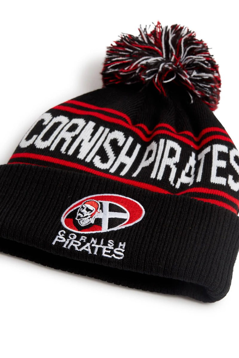 Rex Club | The Rex Club Cornish Pirates Bobble is a black knit beanie with red and white stripes, a pom-pom, "CORNISH PIRATES" text, and a pirate logo—perfect for dedicated Cornish Pirates rugby union fans. | Custom Caps | Custom Hats | Team Headwear | UK