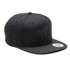 Rex Club | The Rex Club Manchester Titans Snapback is a black, structured baseball cap featuring a flat brim with a round sticker, embroidered front logo, and ventilation eyelets. | Custom Caps | Custom Hats | Team Headwear | UK