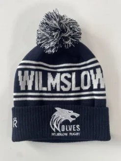 Rex Club | Introducing the Wilmslow Wolves RUFC Bobble Hat: a stylish beanie in navy blue and white featuring a pom-pom on top. It proudly displays "WILMSLOW" across the front, and a fold adorned with a wolf head logo alongside "WOLVES" and "WILMSLOW RUGBY. | Custom Caps | Custom Hats | Team Headwear | UK